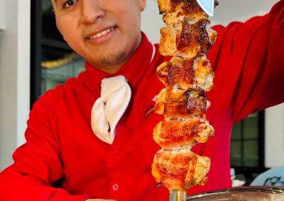 A gaucho ready to serve bacon-wrapped chicken