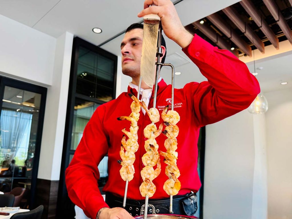 A gaucho ready to serve the grilled shrimp
